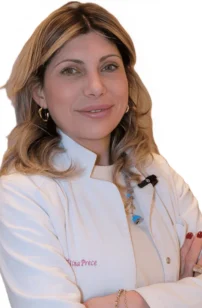 La Dott.ssa Valentina Prece del Coppedè Medical Hub di Roma, una donna dai capelli biondi lunghi fino alle spalle con un camice bianco, si erge sicura di sé con le braccia incrociate e un caldo sorriso su un semplice sfondo bianco.