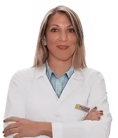 Una donna con lunghi capelli biondi che indossa un camice bianco e un colletto blu sta in piedi con le braccia incrociate e sorride alla telecamera su uno sfondo bianco al Sayaka Papaluca Coppedè Medical Hub di Roma.